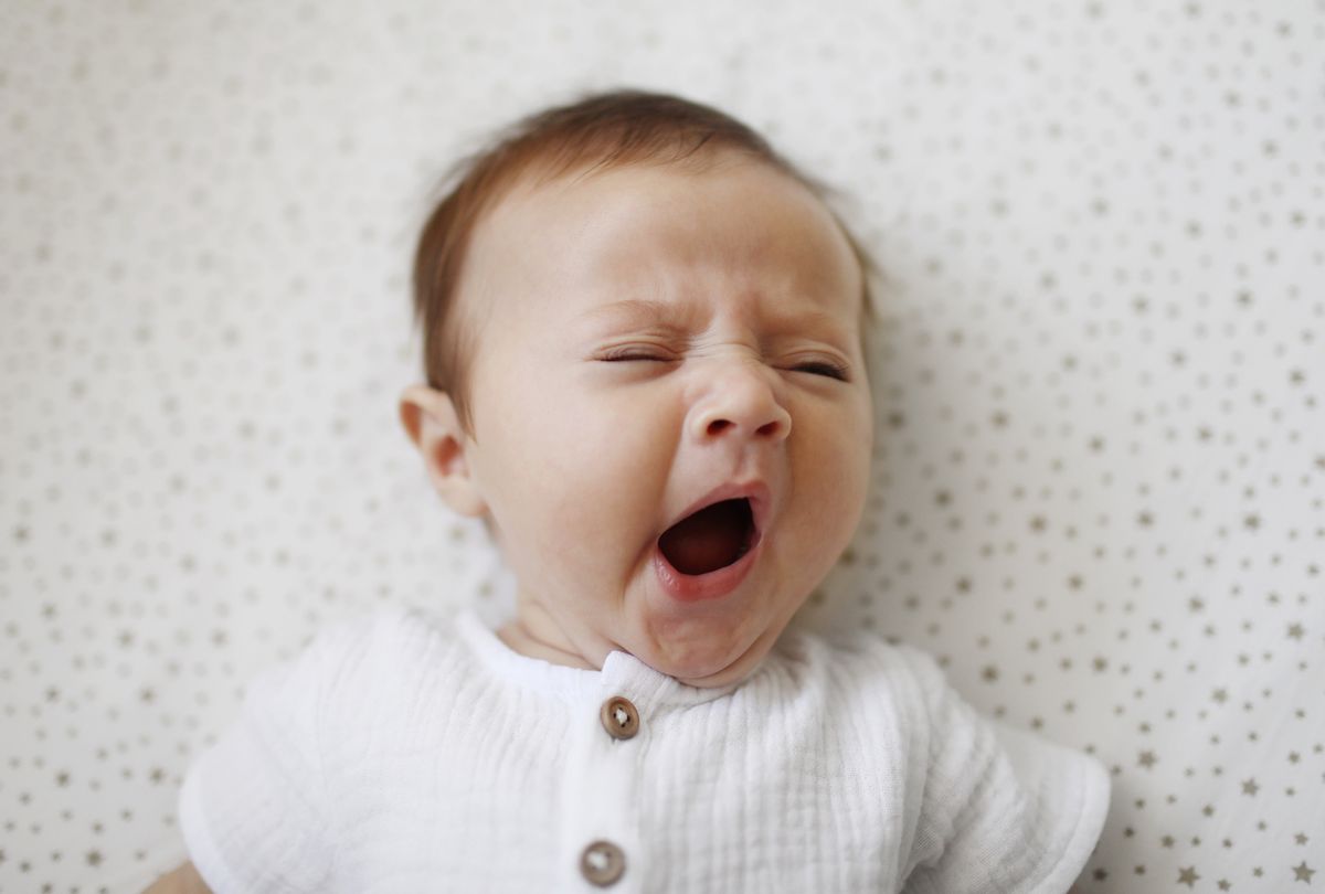A 4 month old baby girl yawning (Catherine Delahaye via Getty Images)