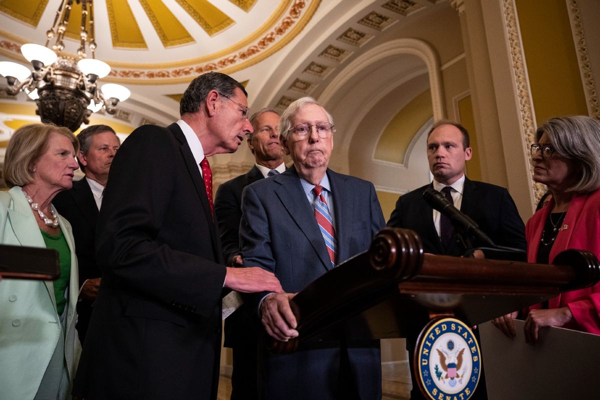 L-R) Sen. John Barrasso (R-WY) reaches out to help Senate Minority Leader Mitch McConnell (R-KY) after McConnell froze and stopped talking at the microphone during a news conference after a lunch meeting with Senate Republicans U.S. Capitol 26, 2023 in Washington, DC. Also pictured, L-R, Sen. Shelley Moore Capito (R-WV), Sen. Steve Daines (R-MT), Sen. John Thune (R-SD) and Sen. Joni Ernst (R-IA). (Drew Angerer/Getty Images)