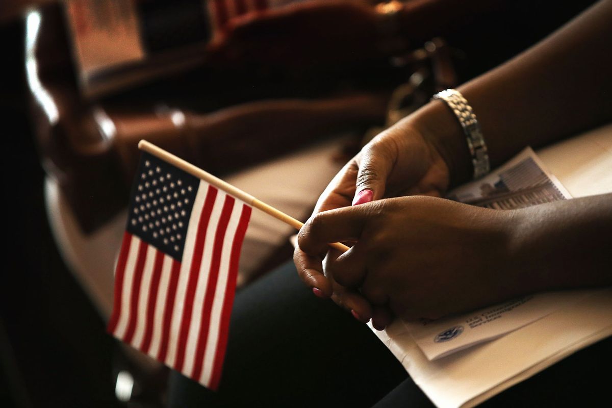 Vishaun Lawrence of Jamaica, a new U.S. citizen, holds and American flag along with her citizenship papers as she participates in a naturalization ceremony at the Chicago Cultural Center on July 3, 2013 in Chicago, Illinois. (Scott Olson/Getty Images)