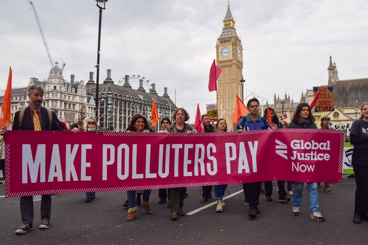 Protesters hold a banner which states "Make polluters pay" during the demonstration in Parliament Square. Thousands of people marched through Westminster in protest against the destruction of nature, biodiversity loss and climate change on Earth Day. (Vuk Valcic/SOPA Images/LightRocket via Getty Images)