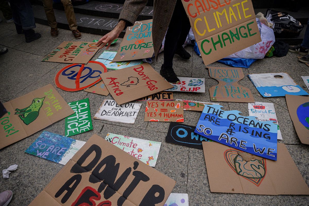 An activist picks up a placard at climate group Fridays for Future's march during a Global Climate Strike in New York on March 3, 2023. (ED JONES/AFP via Getty Images)