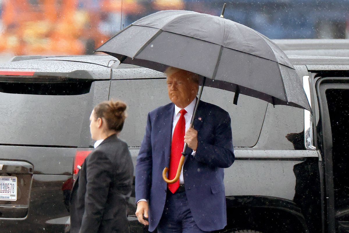 Former U.S. President Donald Trump holds an umbrella as he arrives at Reagan National Airport following an arraignment in a Washington, D.C. court on August 3, 2023 in Arlington, Virginia. (Tasos Katopodis/Getty Images)