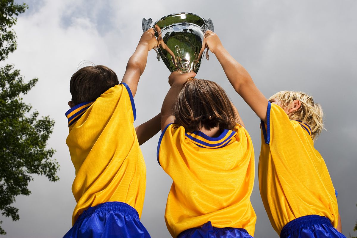 Children in soccer uniforms holding a trophy  (Getty Images / Heide Benser)