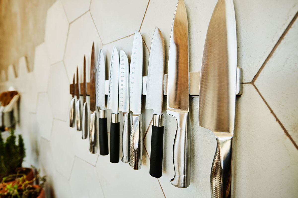 Close up shot of kitchen knives on wall in kitchen (Getty Images/Thomas Barwick)