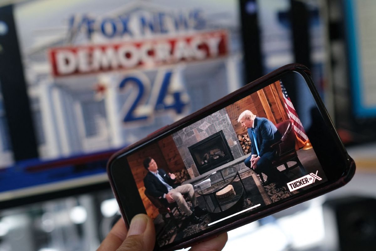 A photo illustration depicting a preview of Tucker Carlson's interview with former U.S. President Donald Trump airing on X (formerly Twitter) on the same night of the first Republican Presidential primary debate in Milwaukee, Wisconsin. (CHRIS DELMAS/AFP via Getty Images)