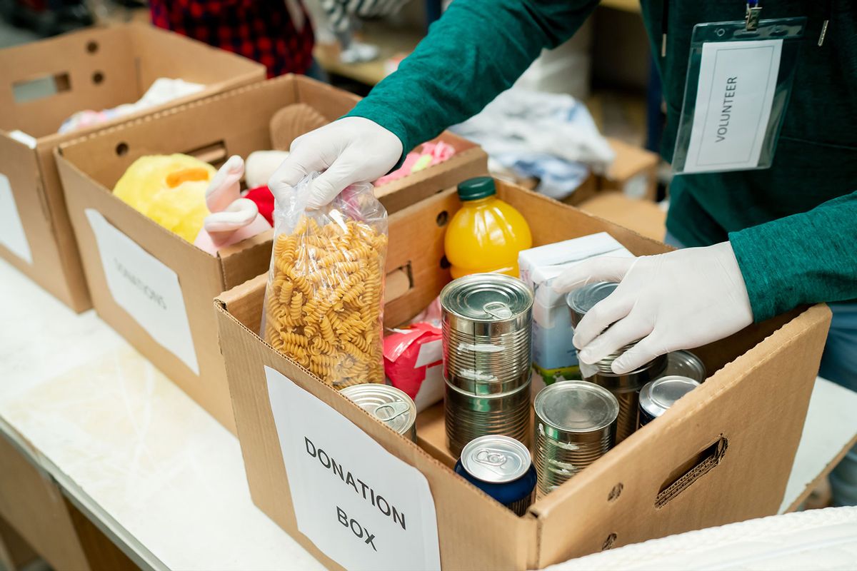 Volunteer organizing donations in boxes wearing protective gloves (Getty Images/Hispanolistic)