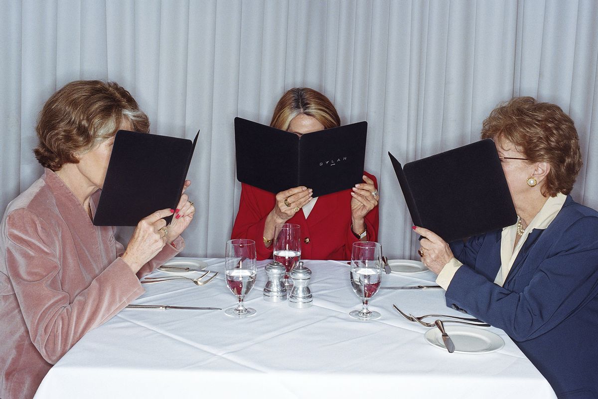 Women looking at the menu in restaurant (Getty Images/Emmanuel Faure)
