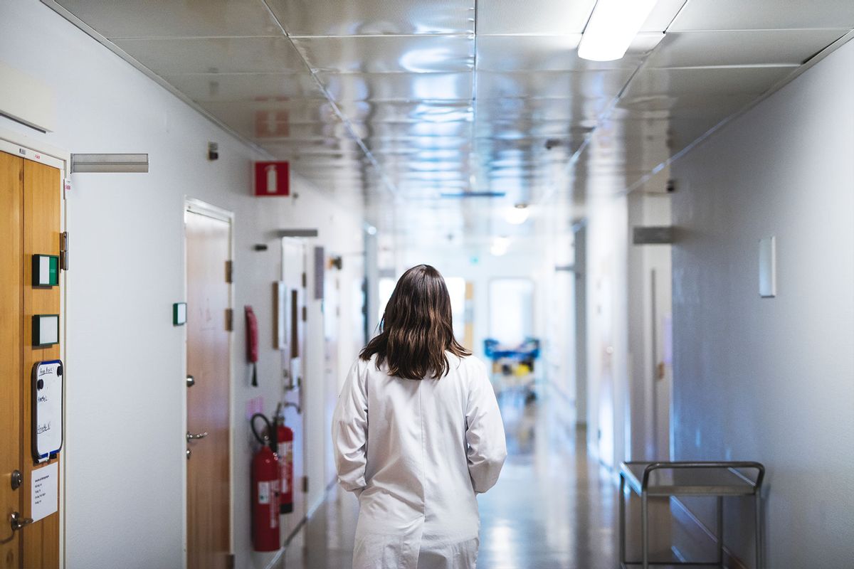 Doctor walking through hospital corridor (Getty Images/Johner Images)