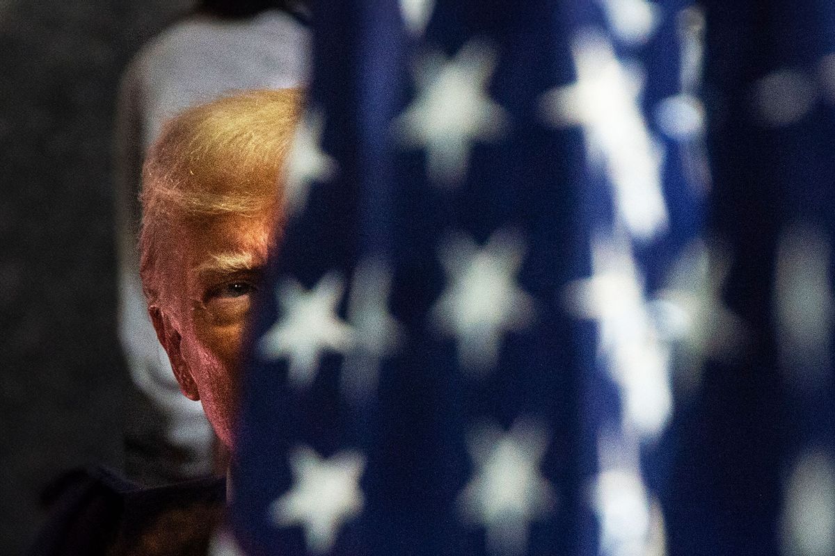 Former US President and 2024 presidential hopeful Donald Trump behind a flag before he speaks at Drake Enterprises, an automotive parts manufacturer and supplier, in Clinton, Michigan, on September 27, 2023. (MATTHEW HATCHER/AFP via Getty Images)