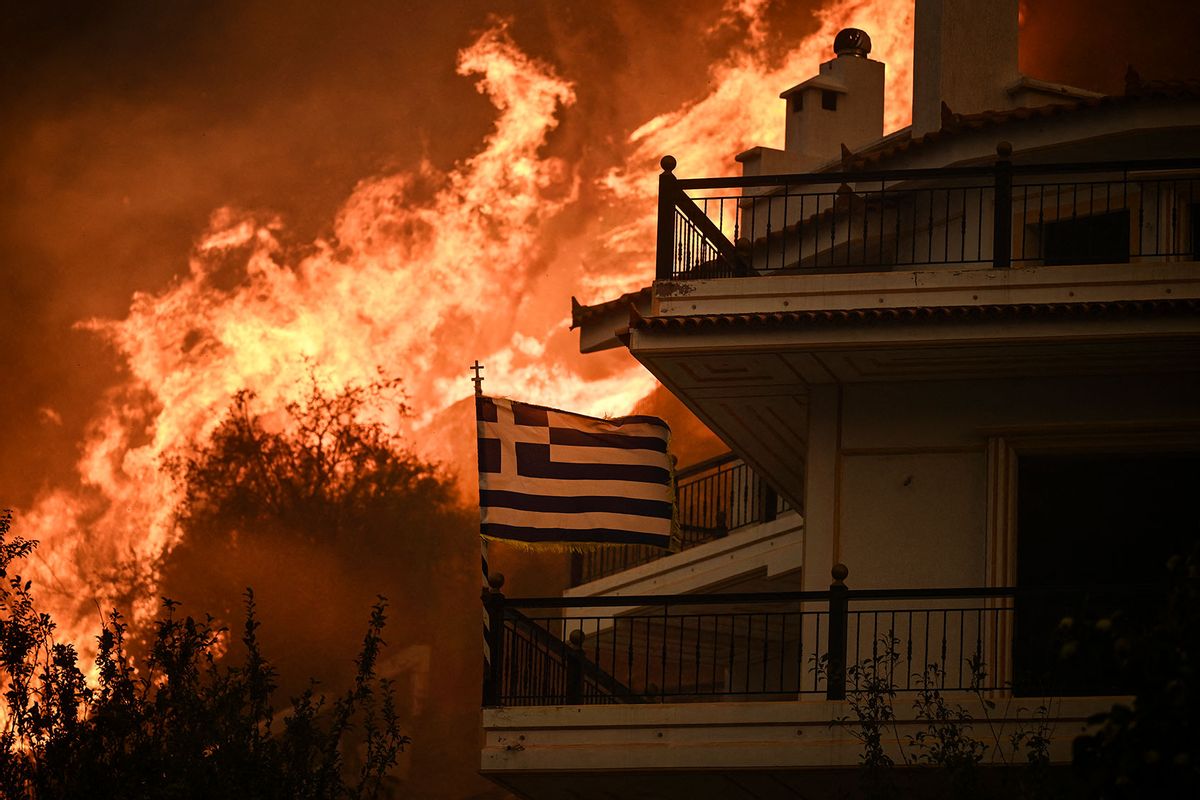 A Greek flag flutters in the wind during a wildfire in Chasia in the outskirts of Athens on August 22, 2023. (ANGELOS TZORTZINIS/AFP via Getty Images)