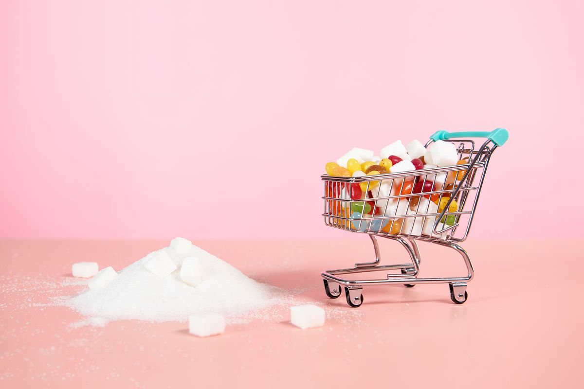 Supermarket trolley with candy next to pile of sugar (Getty Images/Tara Moore)
