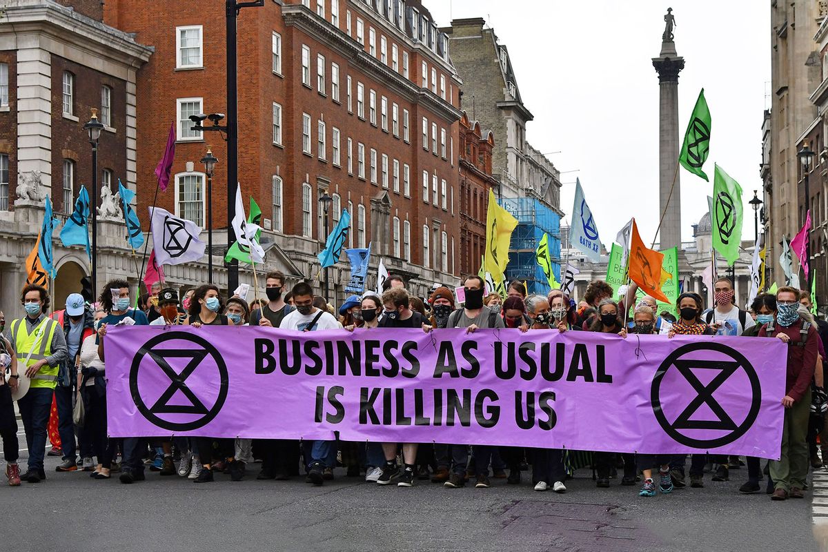 Activists hold a banner reading "Business as usual is killing us" as they take part in an protest by the Extinction Rebellion climate change group, along Whitehall towards Downing Street and the Houses of Parliament, in central London on September 3, 2020 on the third day of their new series of 'mass rebellions'. (JUSTIN TALLIS/AFP via Getty Images)