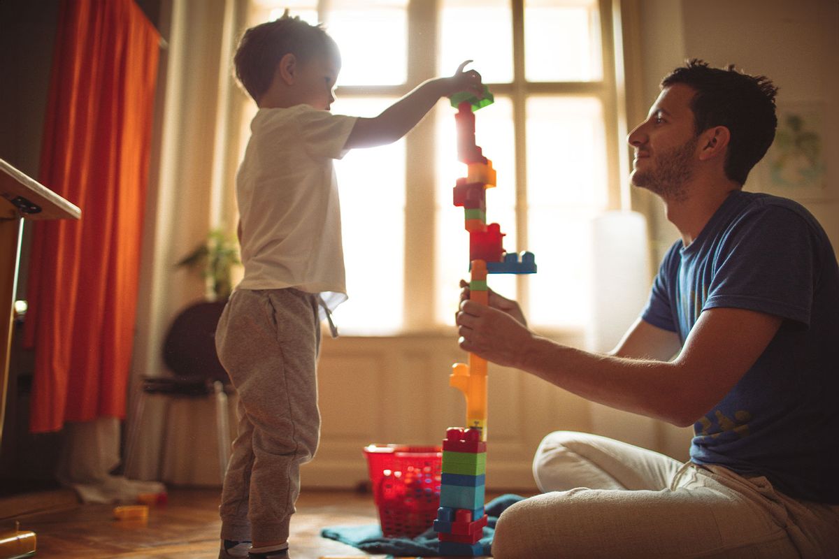 Father and child playing with blocks (Getty Images/AleksandarNakic)