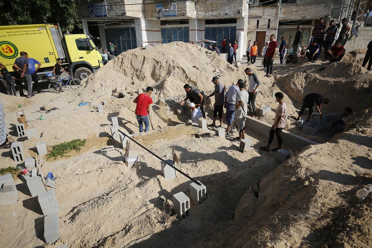 Palestinians who lost their lives in Israeli attacks are buried in mass graves as Israeli attacks continue on the 24th day in Deir al Balah, Gaza on October 30, 2023. (Ashraf Amra/Anadolu via Getty Images)