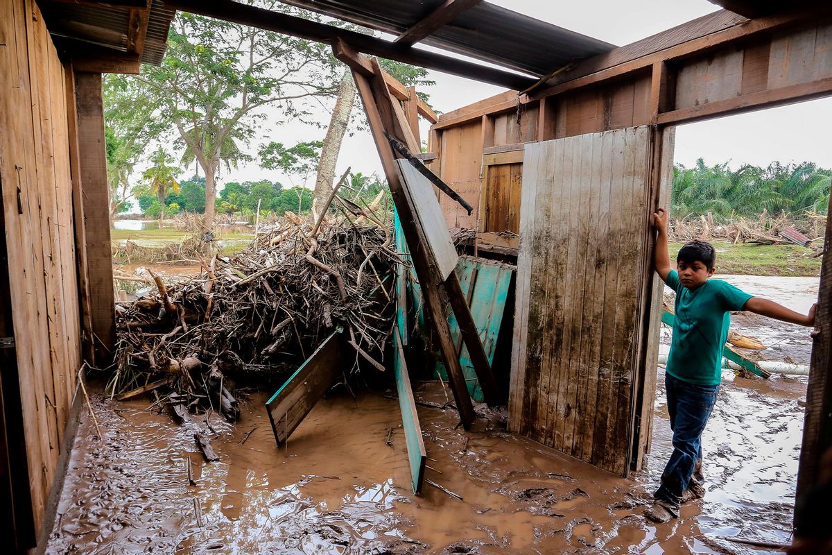 A young boy stands at their home full with mud and debris after the flood caused by Ulua River's overfloow due to heavy heavy rains of Hurricane Iota in Potrerillos municipality near San Pedro Sula, Honduras on November 20, 2020.  (WENDELL ESCOTO/AFP via Getty Images)