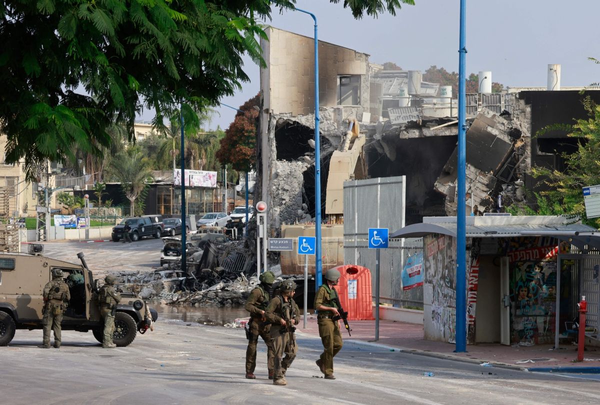 Israeli troops gather around a cordoned-off Israeli police station that was damaged during battles to dislodge Hamas militants who were stationed inside, on October 8, 2023.  (MENAHEM KAHANA/AFP via Getty Images)
