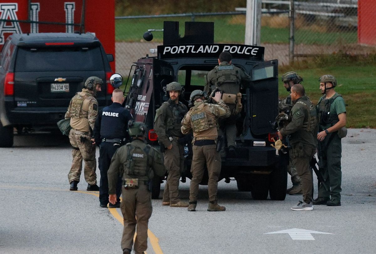 Law enforcement officials load into a tactical vehicle at Lisbon High School at daybreak as a manhunt resumes for the suspect in a mass shooting that took place the day prior.  (Jessica Rinaldi/The Boston Globe via Getty Images)