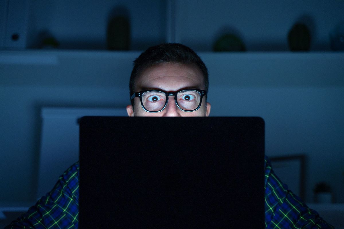 Man using laptop at night (Getty Images/tommaso79)