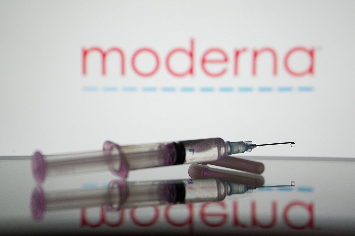 In this photo illustration, a medical syringe is displayed on a screen, and the logo of Moderna in the background. (Photo Illustration by Nikos Pekiaridis/SOPA Images/LightRocket via Getty Images)