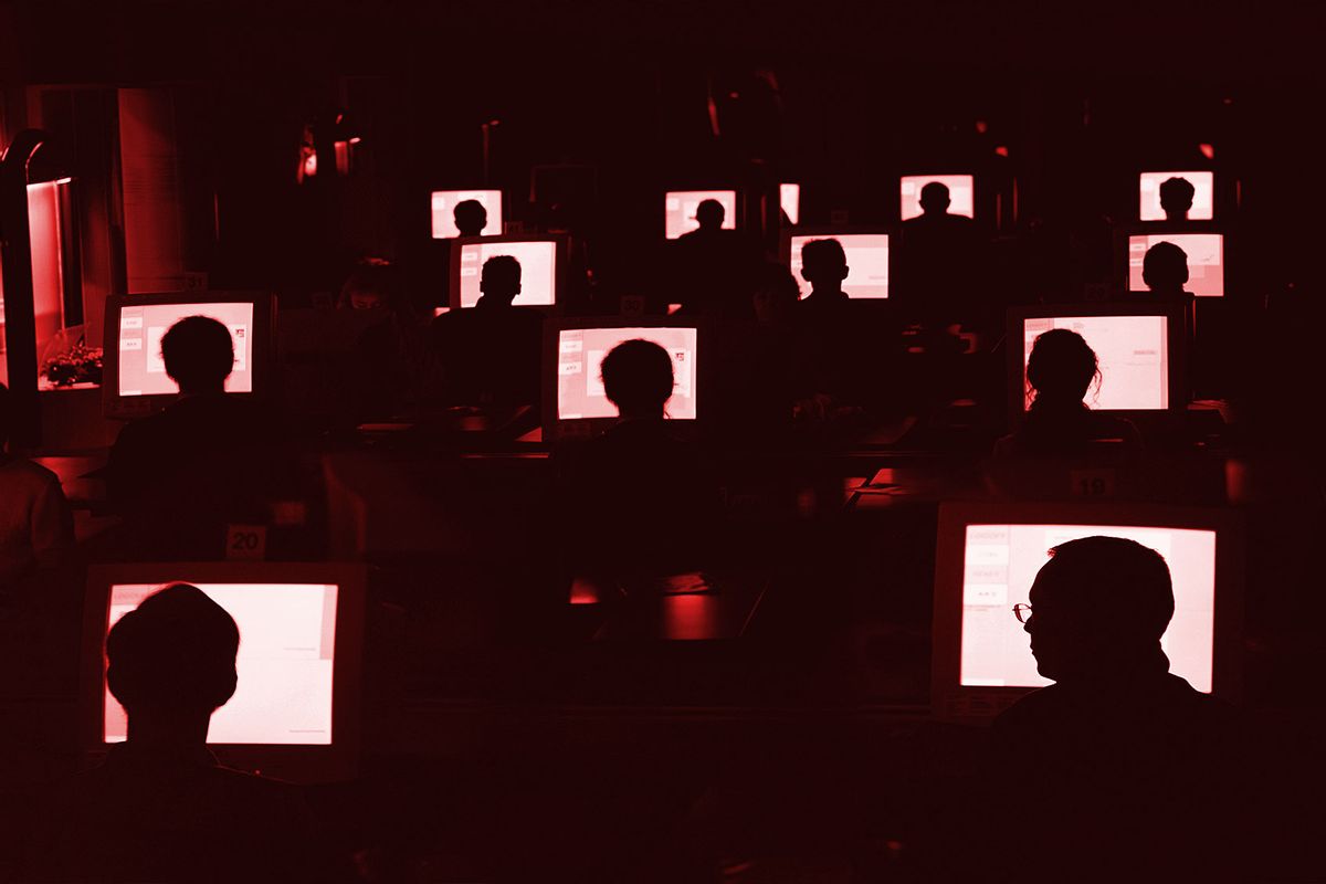 People at computers in the dark (Getty Images/David Trood)