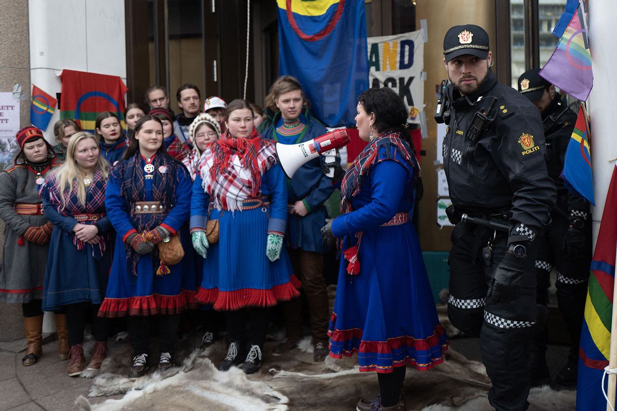 The president of the Sami Parliament, Silje Karine Muotka (2R) in traditional outfit delivers a speech in front of activists from the "Nature and Youth" and "Norwegian Samirs Riksforbund Nuorat" as they were blocking the Ministery of finances to protest against wind turbines built on land traditionally used to her reindeer, in Oslo, on March 2, 2023. (OLIVIER MORIN/AFP via Getty Images)