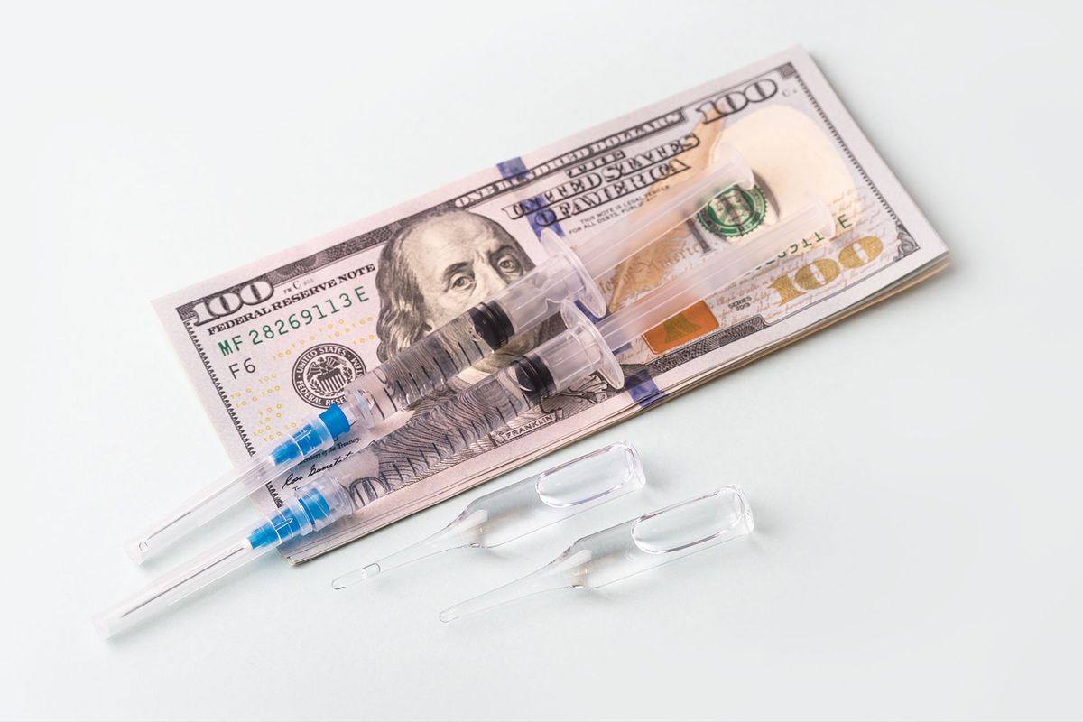 Medical syringe and vaccine with cash (Getty Images/Yulia Naumenko)