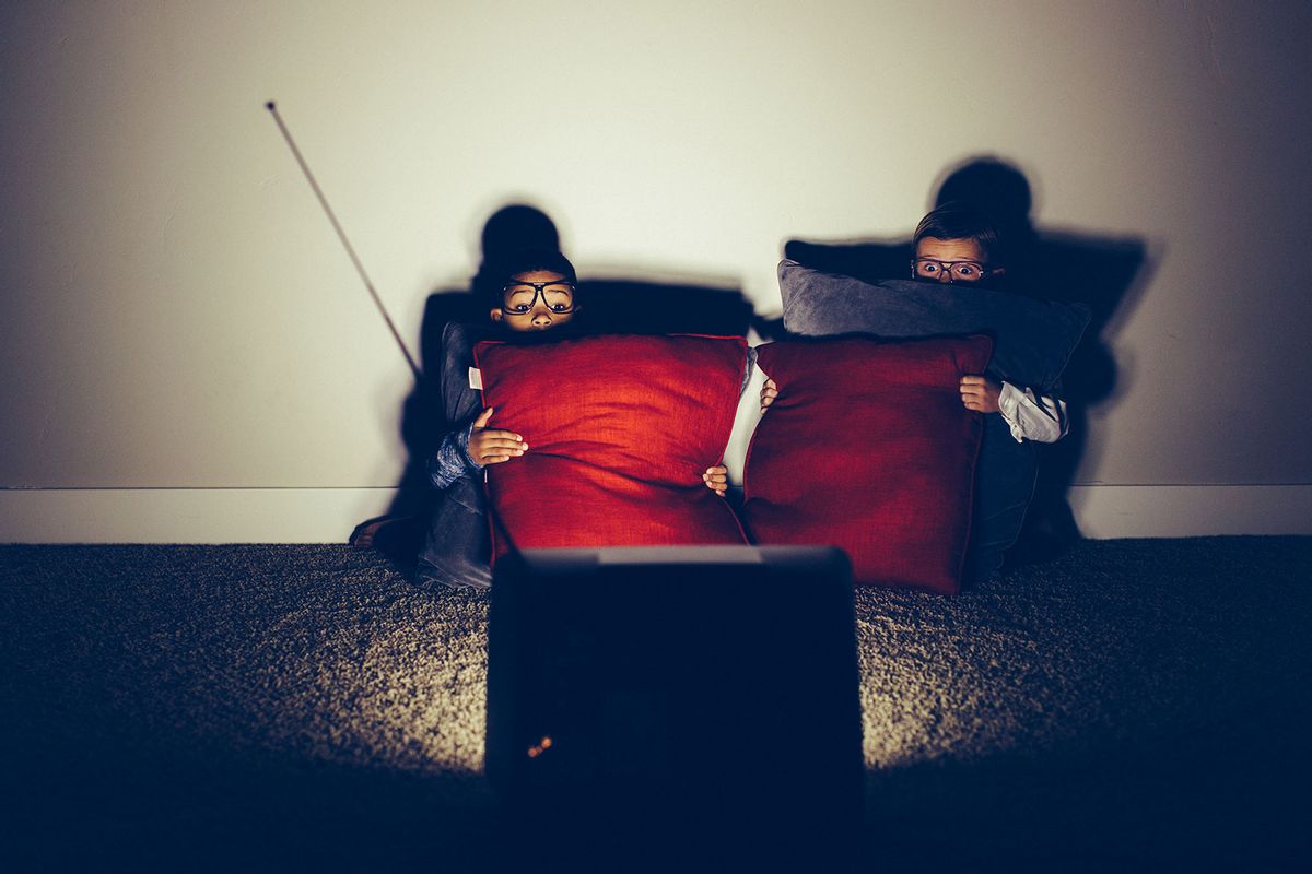 Two young boys sit in a basement late at night on a weekend watching a horror flick. (Getty Images/RichVintage)
