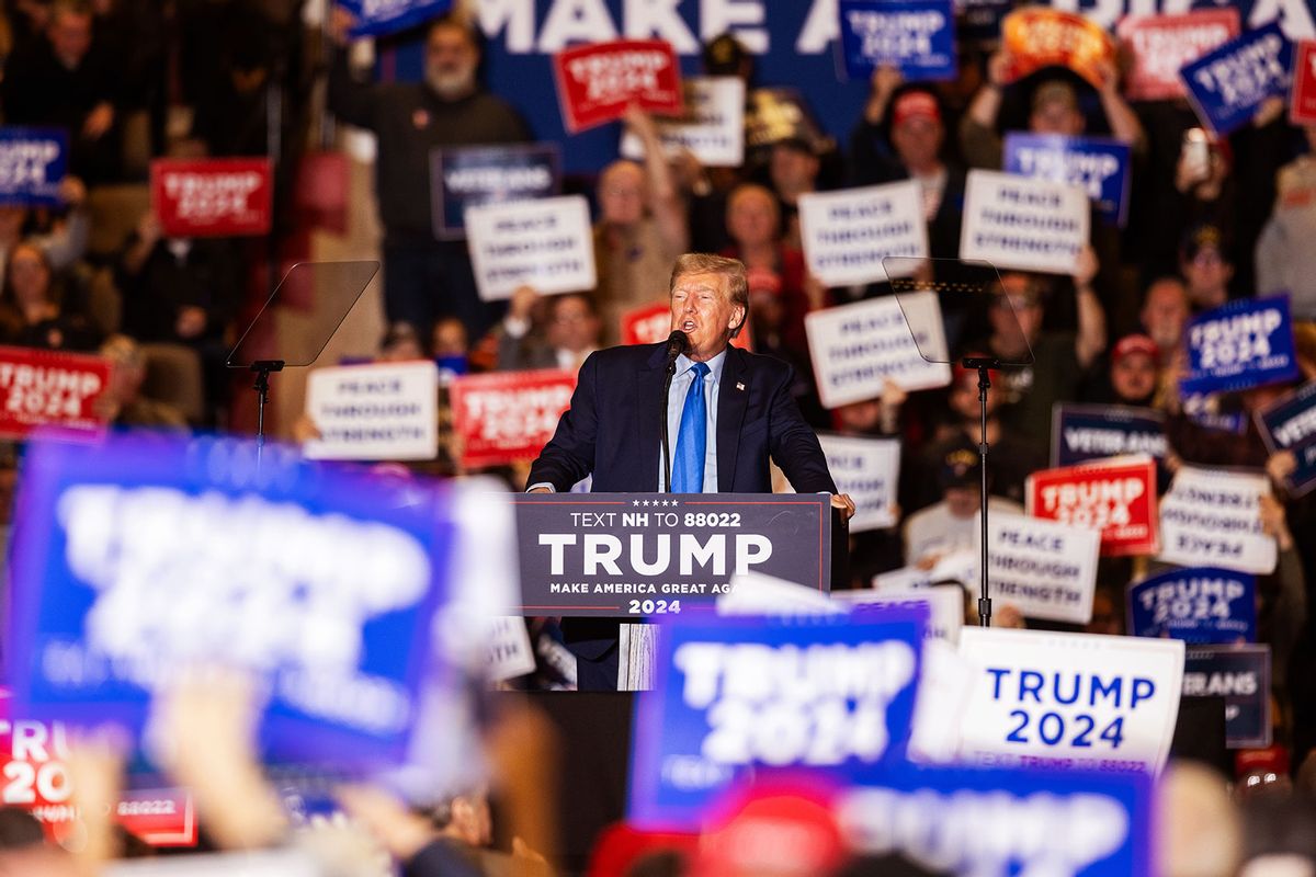 A supporter of Republican presidential candidate former President Donald Trump hold up signs while he delivers remarks during a campaign event on November 11, 2023 in Claremont, New Hampshire. (Scott Eisen/Getty Images)