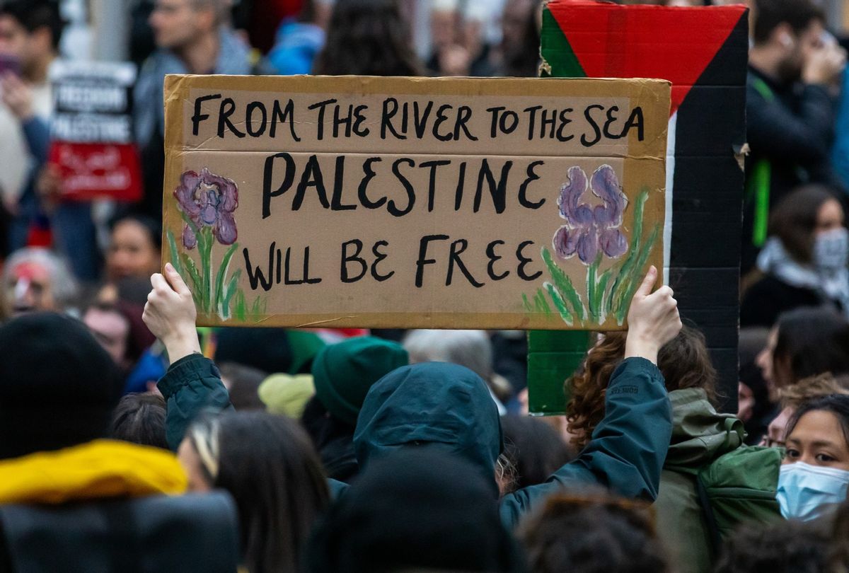 A pro-Palestinian activist holds up a sign reading 'From The River To The Sea Palestine Will Be Free' during a sit-down protest to call for an immediate ceasefire in Gaza on 4th November 2023 in London, United Kingdom. (Mark Kerrison/In Pictures via Getty Images)
