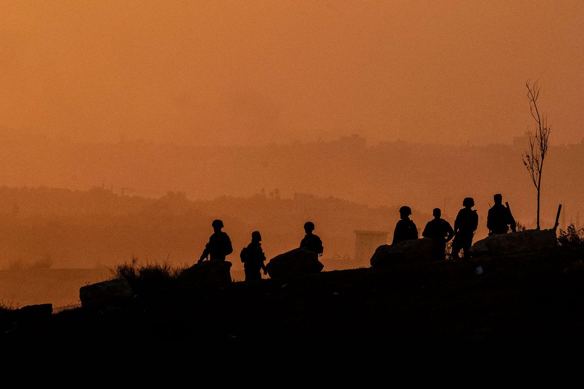 This picture taken on October 31, 2023 from a position near Sderot along the border with the Gaza Strip in southern Israel shows Israeli army soldiers standing on a hilltop facing the Palestinian territory amid ongoing battles between Israel and the Palestinian Hamas movement. (Yuri CORTEZ / AFP) (Photo by YURI CORTEZ/AFP via Getty Images)