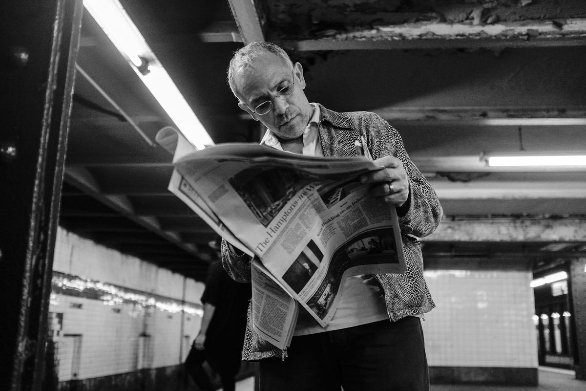 A man reads The New York Times newspaper May 10, 2014 while waiting for a subway in New York City. (Robert Nickelsberg/Getty Images)