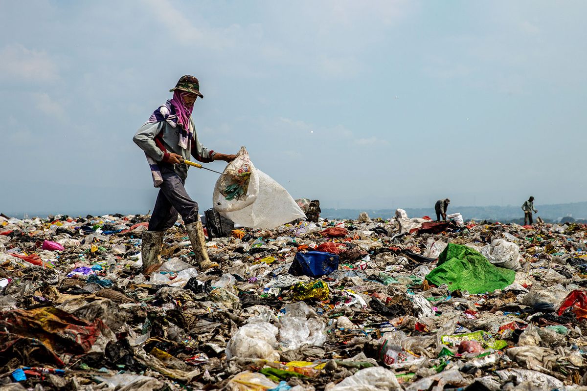 A scavenger looks for plastic bottles at Jabon landfill on April 22, 2021 in Sidoarjo, East Java, Indonesia. (Robertus Pudyanto/Getty Images)