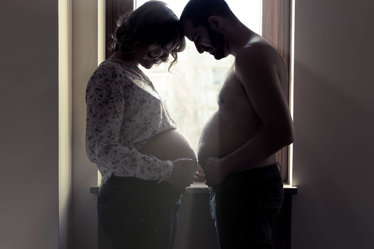 Pregnant couple showing each other their bellies (Getty Images/paolomartinezphotography)