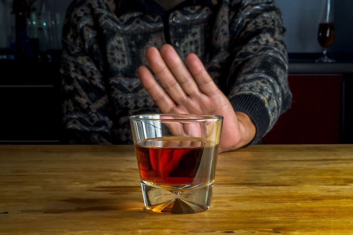 Male hand rejecting glass with alcoholic beverage (Getty Images/Sergiy Katrych)