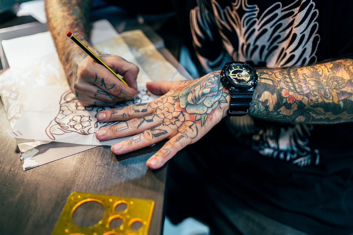 Tattoo artist designing motifs (Getty Images/Westend61)