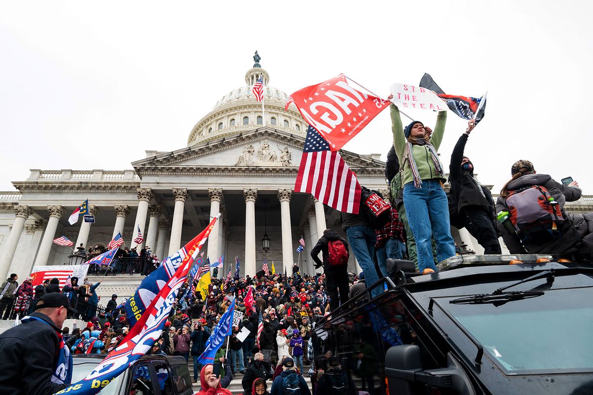 Trump supporters stand on the U.S. Capitol Police armored vehicle as others take over the steps of the Capitol on Wednesday, Jan. 6, 2021, as the Congress works to certify the electoral college votes. (Bill Clark/CQ-Roll Call, Inc via Getty Images)