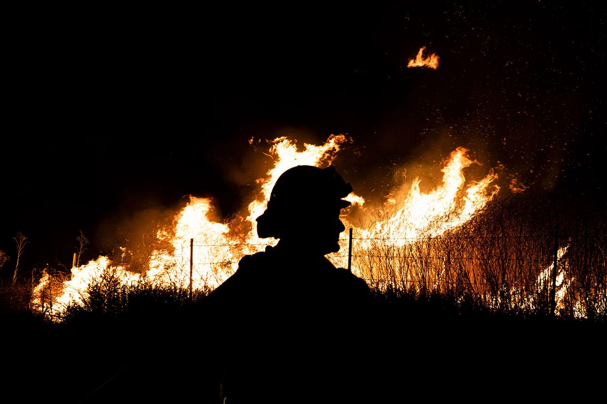 A CalFire (California Department of Forestry and Fire Protection) firefighter seen silhouetted against the raging flames. CalFire firefighters take on the Rabbit Fire that is currently taking over Moreno Valley, California on July 14, 2023. (Jon Putman/SOPA Images/LightRocket via Getty Images)
