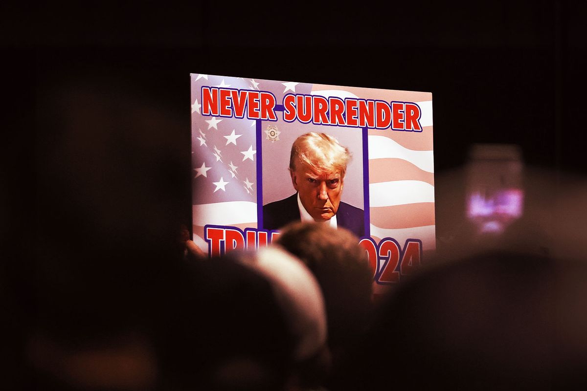 Supporters of Republican Presidential candidate former U.S. President Donald Trump hold a sign as he delivers remarks during a campaign rally at the Reno-Sparks Convention Center on December 17, 2023 in Reno, Nevada. (Justin Sullivan/Getty Images)