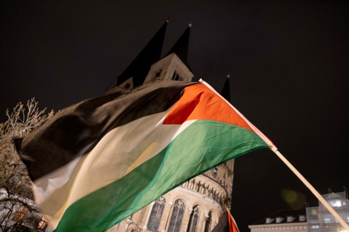 A Palestinian flag is waved in front of Bonn Minster during the "Stop the genocide in Gaza" demonstration on the war in the Middle East.  ( Thomas Banneyer/picture alliance via Getty Images)