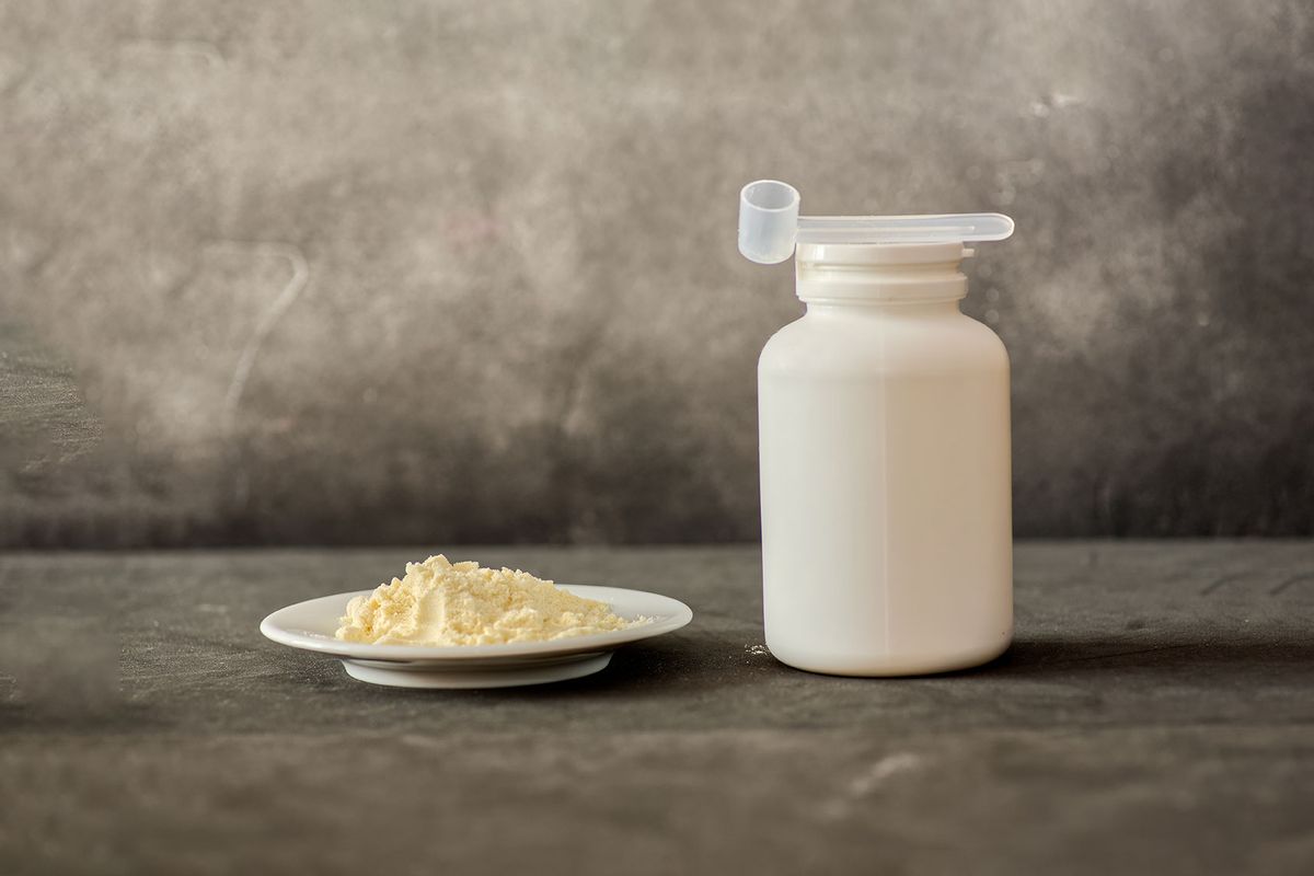 Heap of bovine colostrum powder on plate and white plastic container with measuring scoop (Getty Images/Tatiana Sidorova)