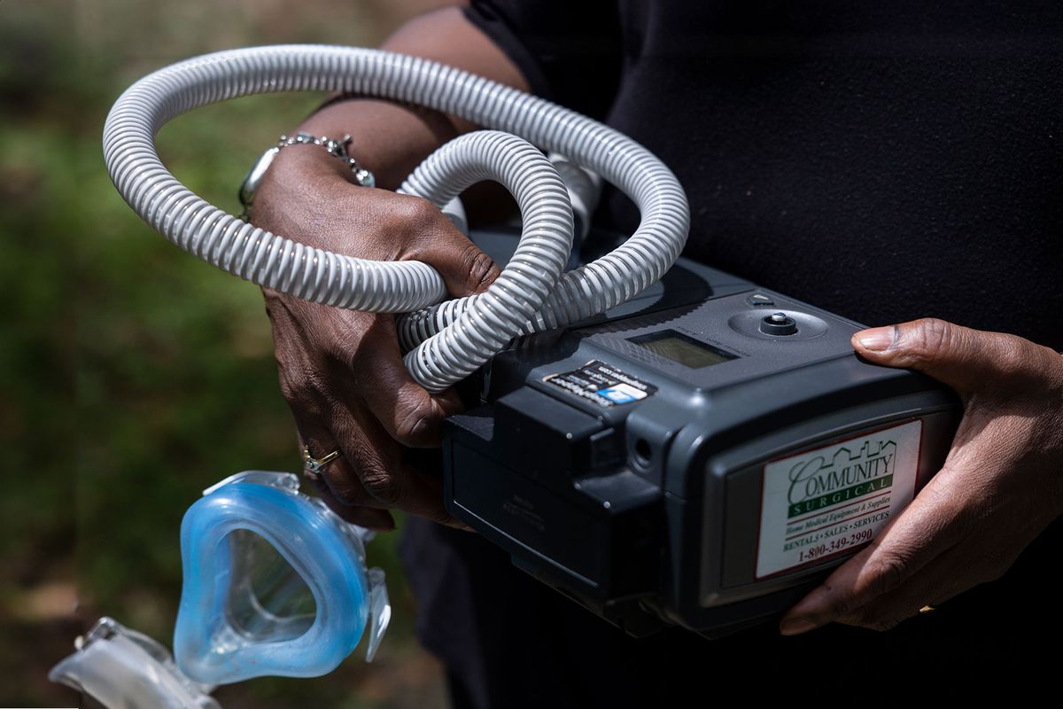 Jenny Shields poses for a photo with her CPAP machine, which was recalled for safety reasons, at her home in Wilmington, Delaware on June 3, 2022. (Rachel Wisniewski/For the Washington Post)