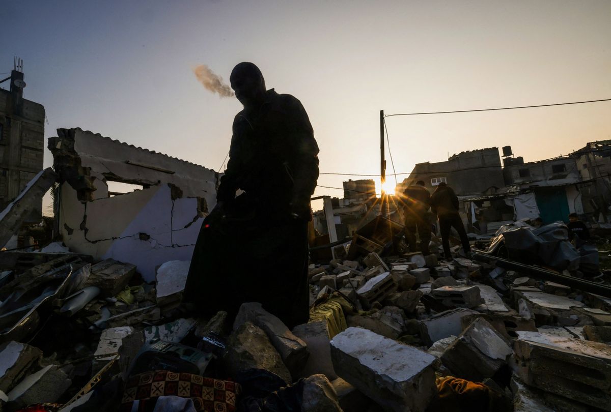 A man standing on the rubble of a building destroyed by Israeli bombardment smokes a cigarette in Rafah refugee camp, south of the Gaza Strip, on January 1, 2024, amid the ongoing conflict between Israel and the Palestinian militant group Hamas. (AFP via Getty Images)