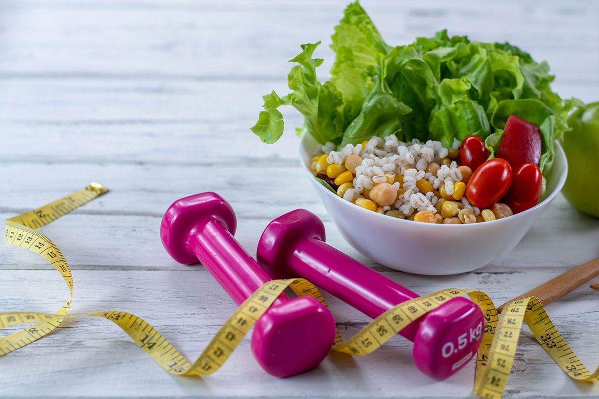 Healthy lifestyle concept. Dumbbell, vegetable salad and measuring tape. (Getty Images/athima tongloom)