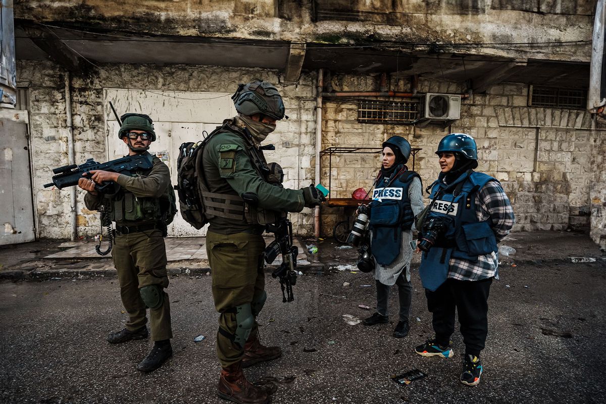 Israeli soldiers stop an inspect identification for photojournalists Raneen Sawafta and Shatha Hanaysha covering the news as Israeli forces conduct raid operations throughout the city in Jenin, Occupied West Bank , Wednesday, Dec. 13, 2023. (Marcus Yam / Los Angeles Times / Getty Images)