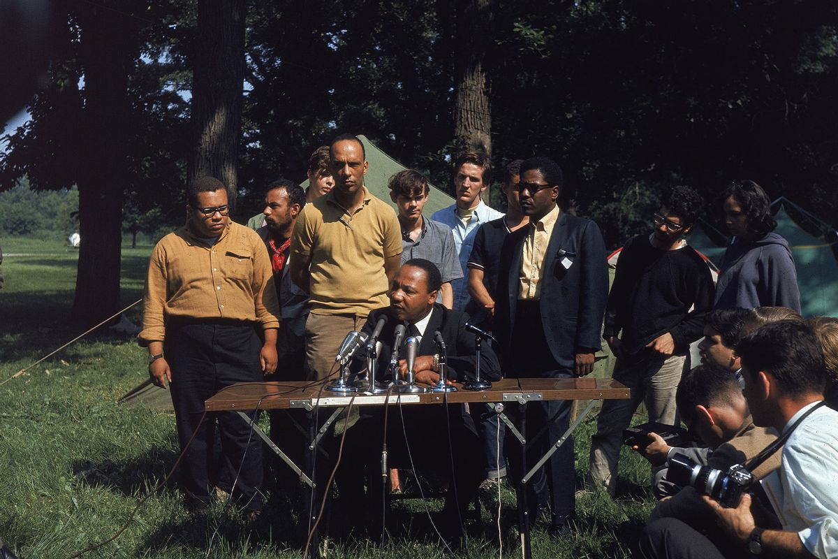 American civil rights activists (L - R) Al Raby, Mike Lawson, Bernard Lee, and Dr. Martin Luther King, Jr. (seated, 1929 - 1968) hold an outdoor press conference at the Cenacle "tent-in" at Warrenville, Illinois, June 23, 1967. (Pictorial Parade/Getty Images)