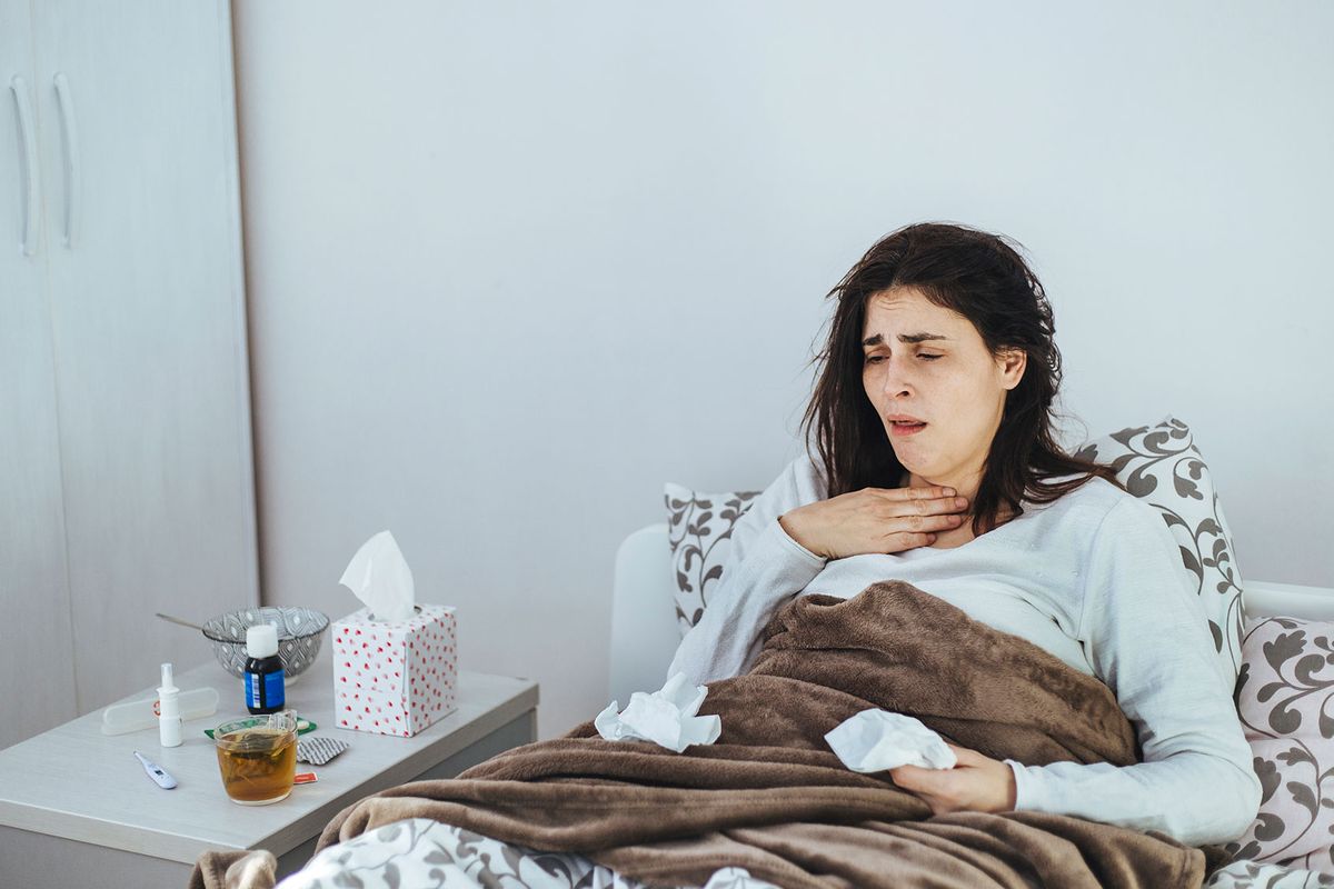 Woman Suffering From A Cold Lying In Bed (Getty Images/Obradovic)