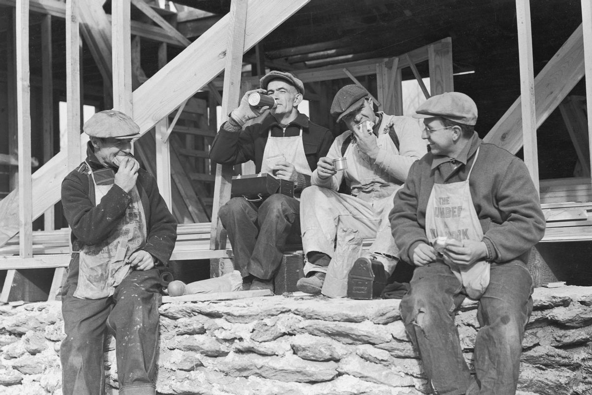 circa 1945: Four workers sit around a construction site, eating lunch from paper bags and lunchboxes and drinking from thermoses. (Harold M. Lambert/Lambert/Getty Images)