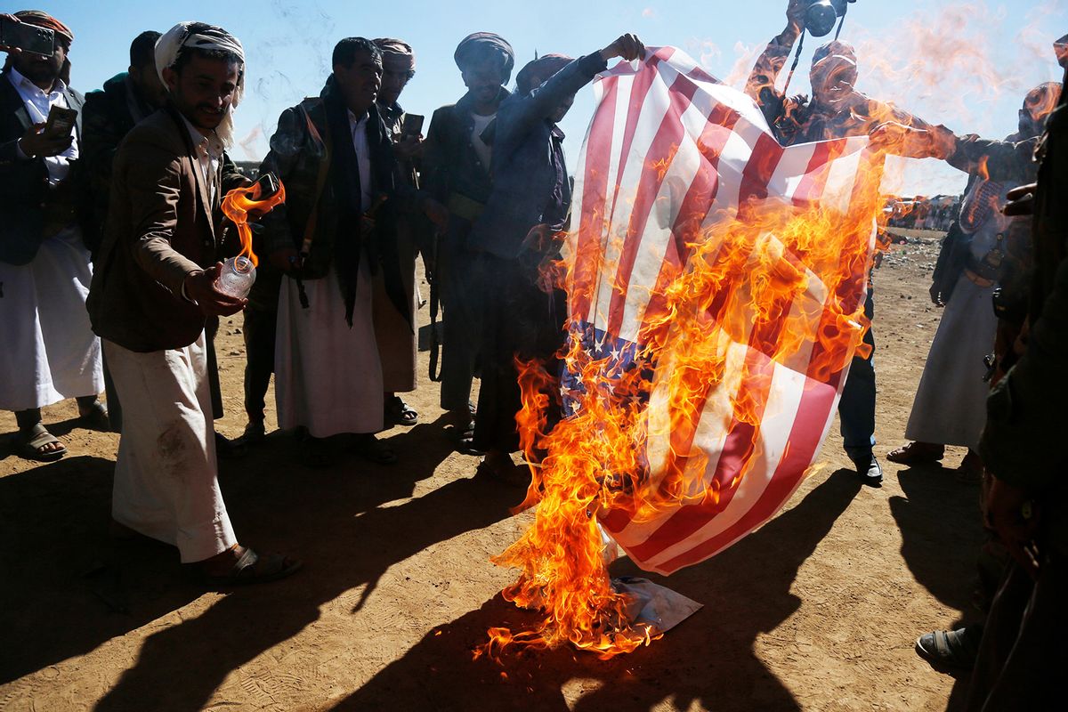 Houthi followers burn the Israeli and American flags during a gathering on January 14, 2024 on the outskirts of Sana'a, Yemen. (Mohammed Hamoud/Getty Images)