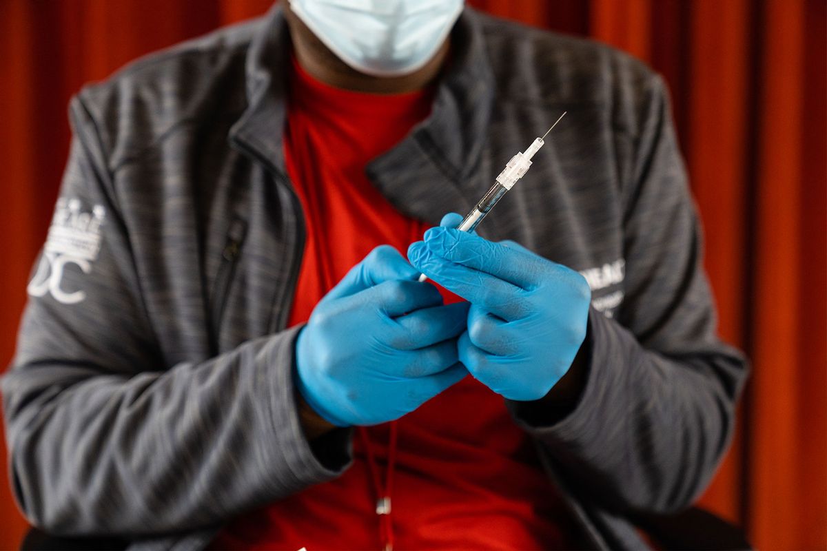 Malik Jaffer, lead nurse, prepares a syringe with a Covid-19 vaccine, at the Peoples Congregational United Church of Christ, the site of the Ward 4 DC Covid Center, in Washington, D.C. on March 31, 2023. (Eric Lee for The Washington Post via Getty Images)