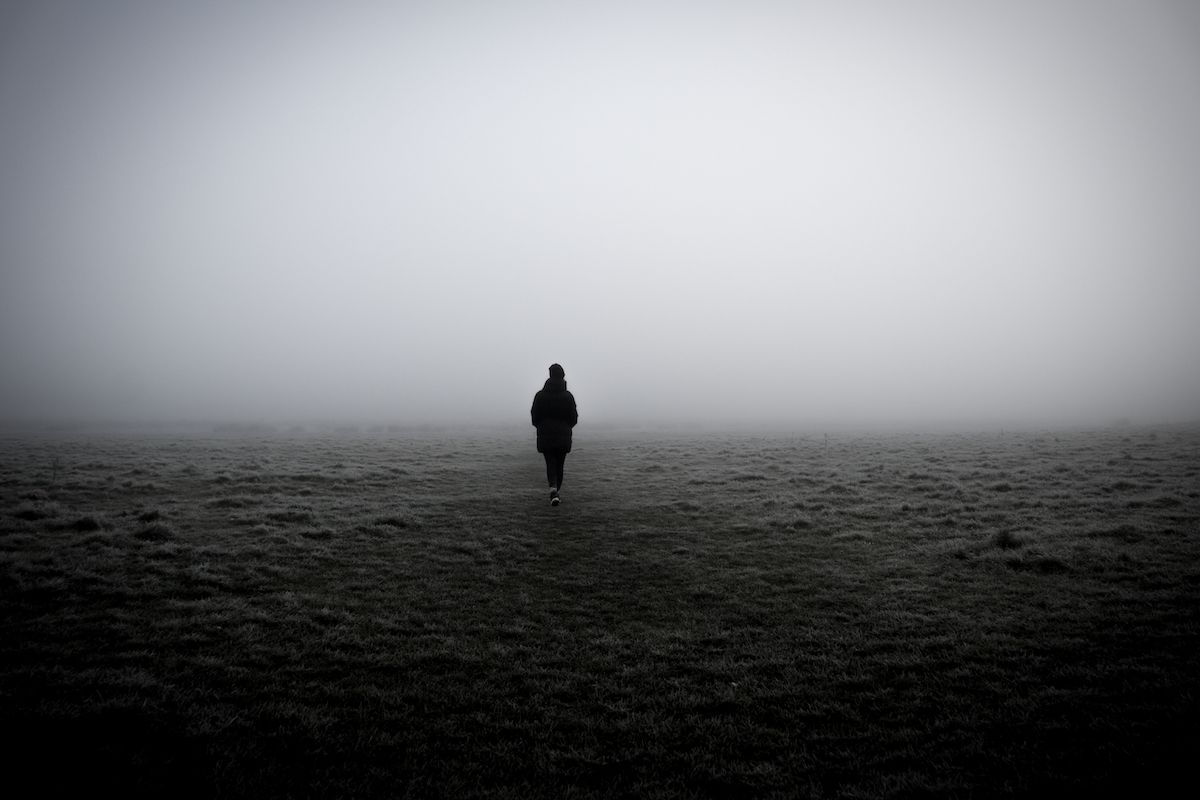 A closeup of a woman walking in a foggy field (Wirestock / Getty Images)